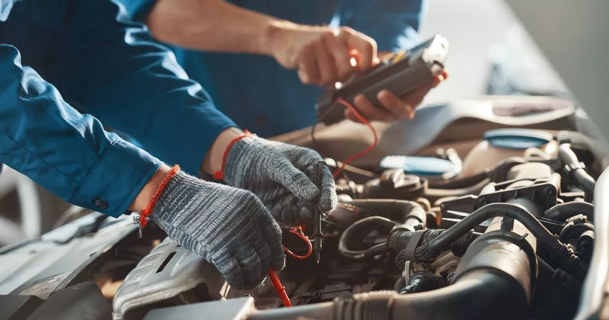 0 Midsection of mechanic repairing car engineRomania