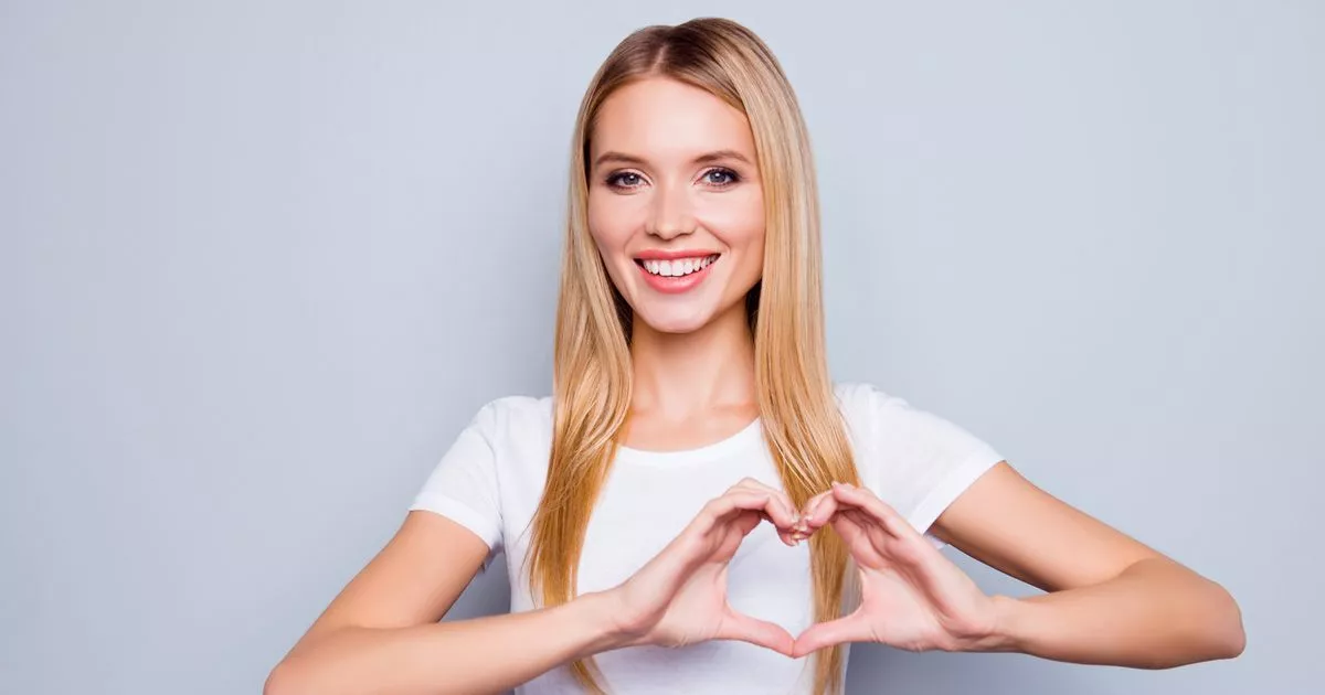 0 Portrait of happy smiling cheerful joyful attractive woman making a heart using her hands isolated
