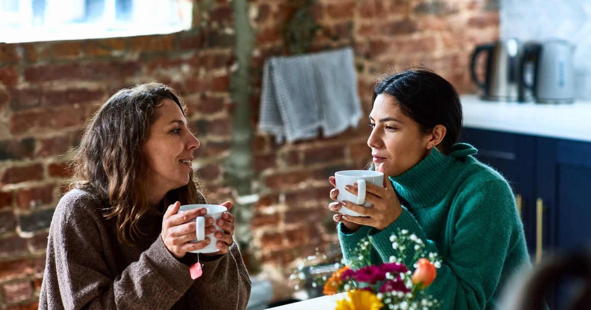 0 Two women enjoying hot drink having conversation 1