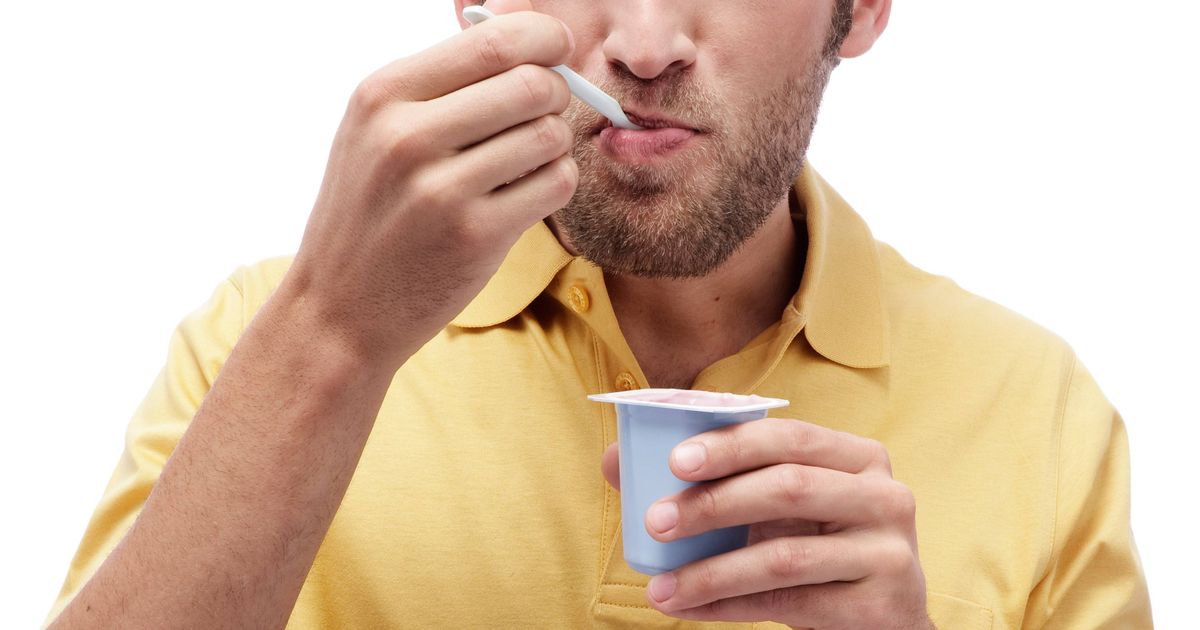 0 Young man eating Yoghurt portrait