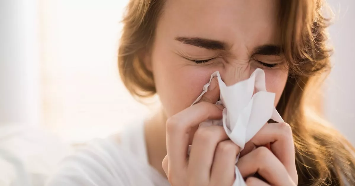 1 Woman blowing her nose on couch