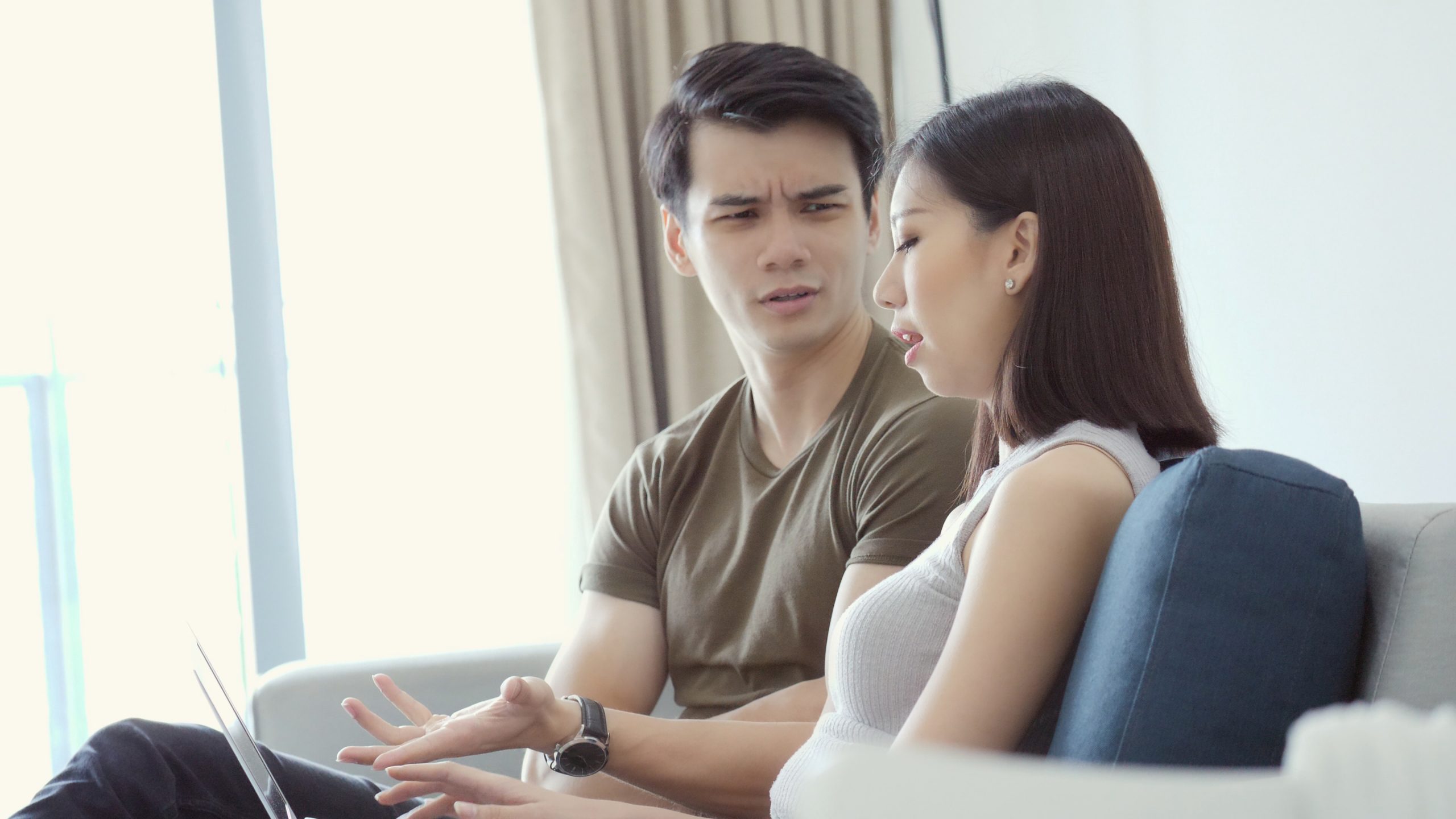 couple talking while woman looks at laptop scaled