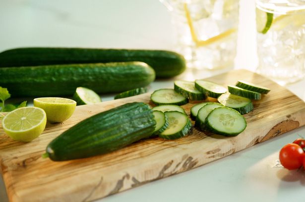 0 Cucumber and lime on wooden cutting board for refreshing drink