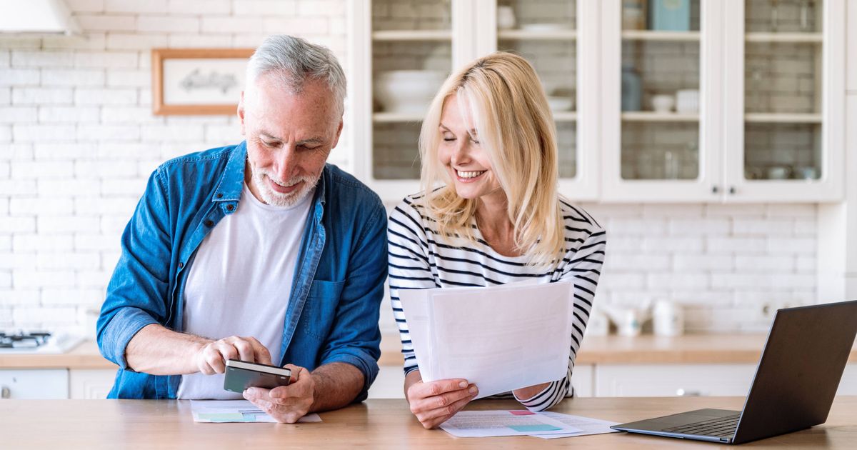 0 Happy mature family couple managing household budget together