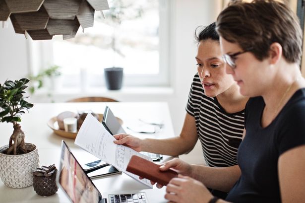 0 Lesbian couple discussing over financial bills while using laptop at table