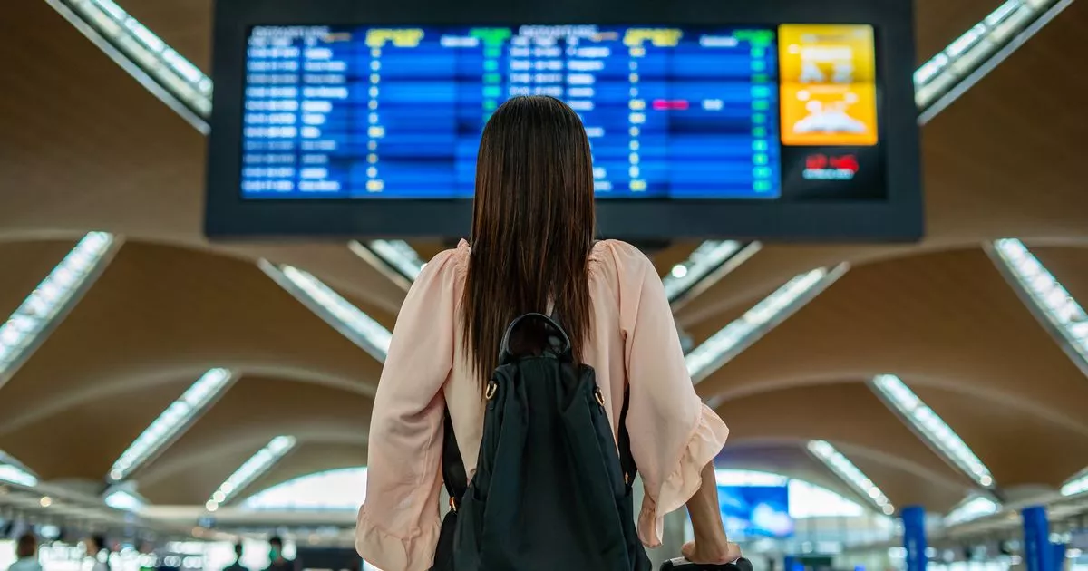 0 Person staring at departure boards in an airport
