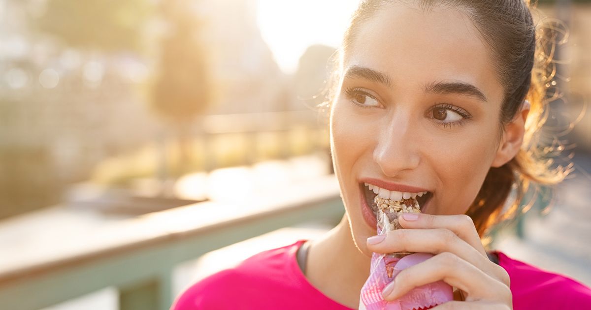 0 Sporty woman eating energy bar