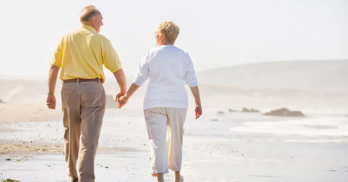10 Mature couple walking on beach