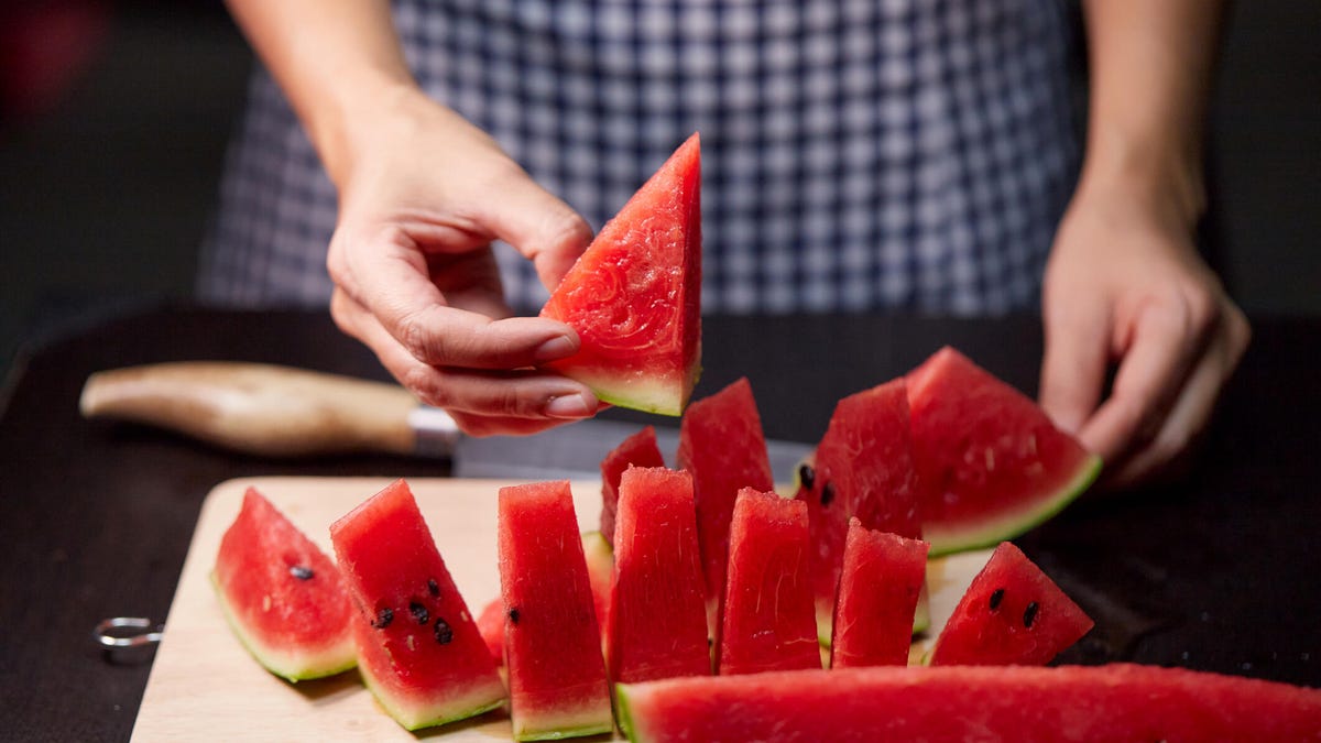 person cutting watermelon