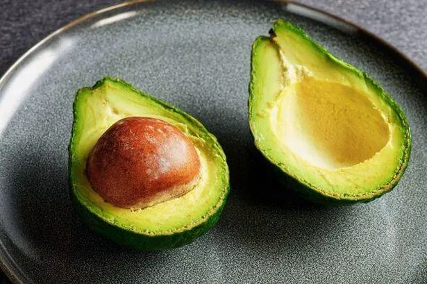 0 Close up view of an avocado cut in half with both halves and pit