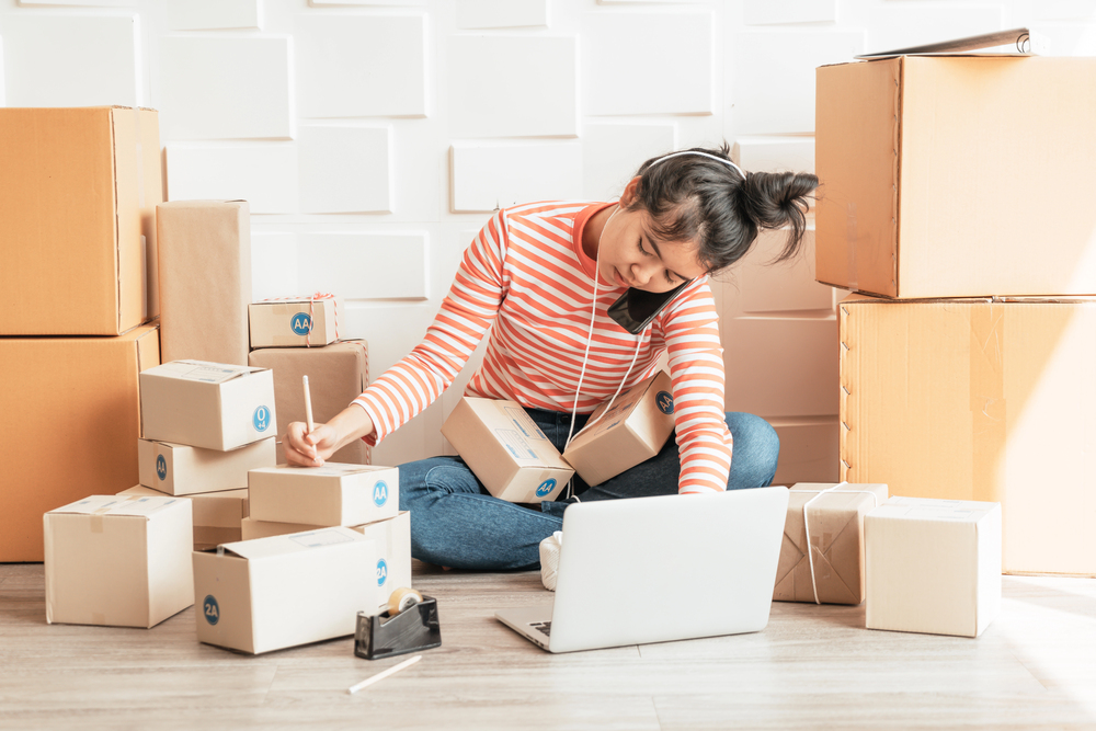 An Amazon entrepreneur boxing packages up from home for Amazon work at home jobs blog post
