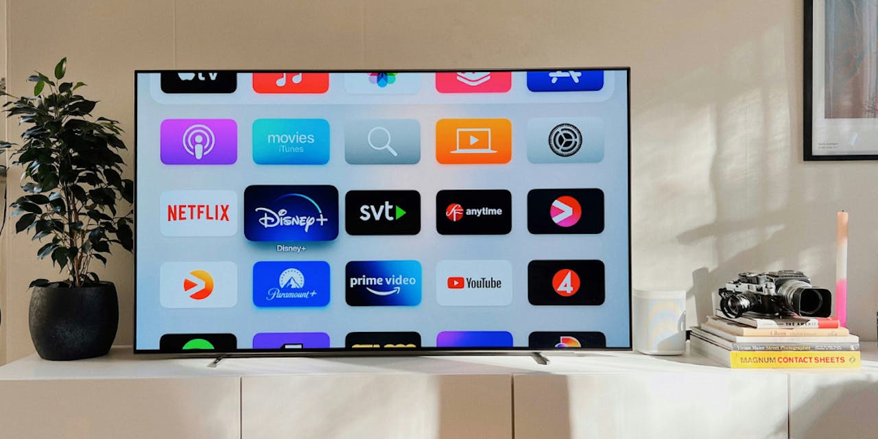 flat screen tv sitting on a white cabinet oscar nord unsplash