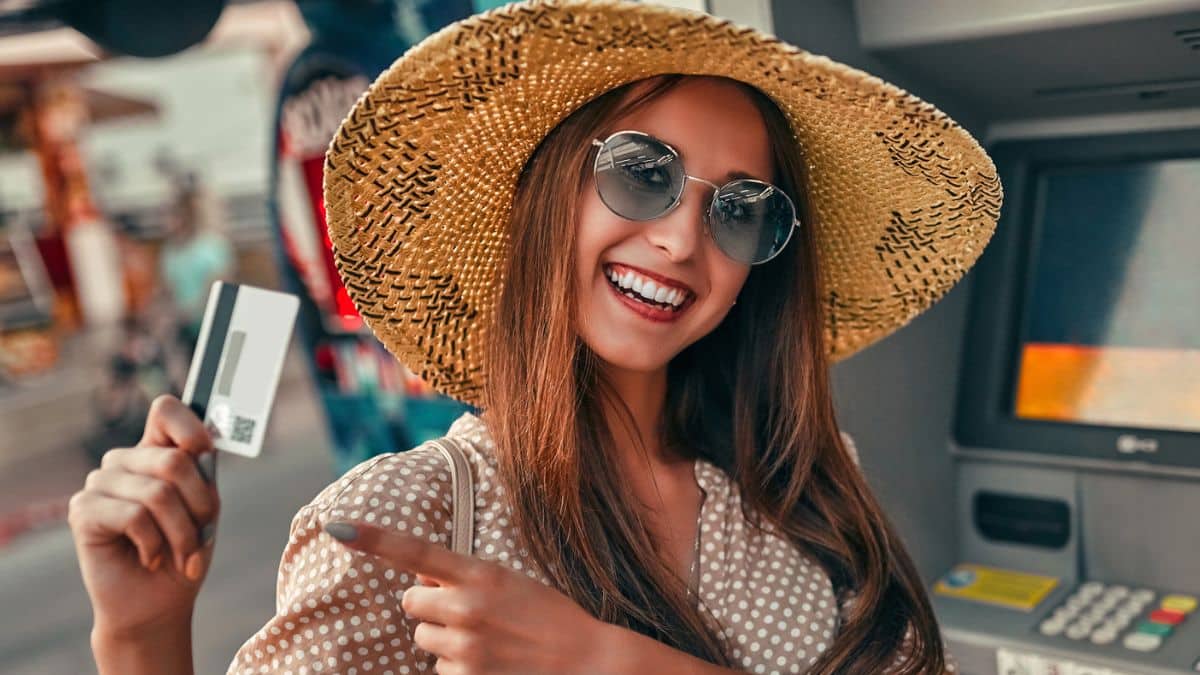 woman holding credit card in front of atm
