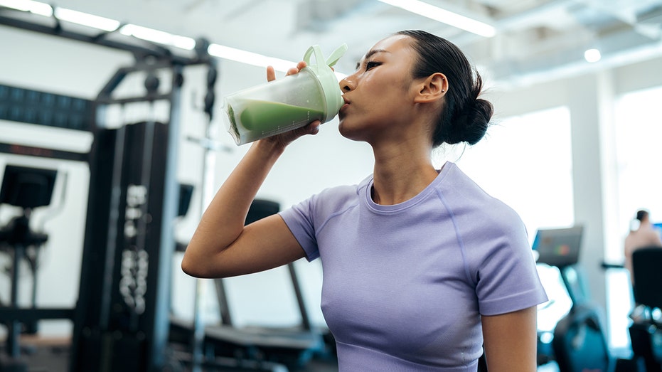 woman drinks creatine gym