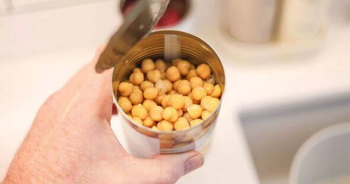 0 Hand holding an open can of chickpeas