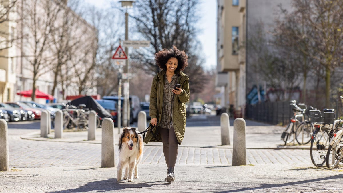 woman walking dog in city