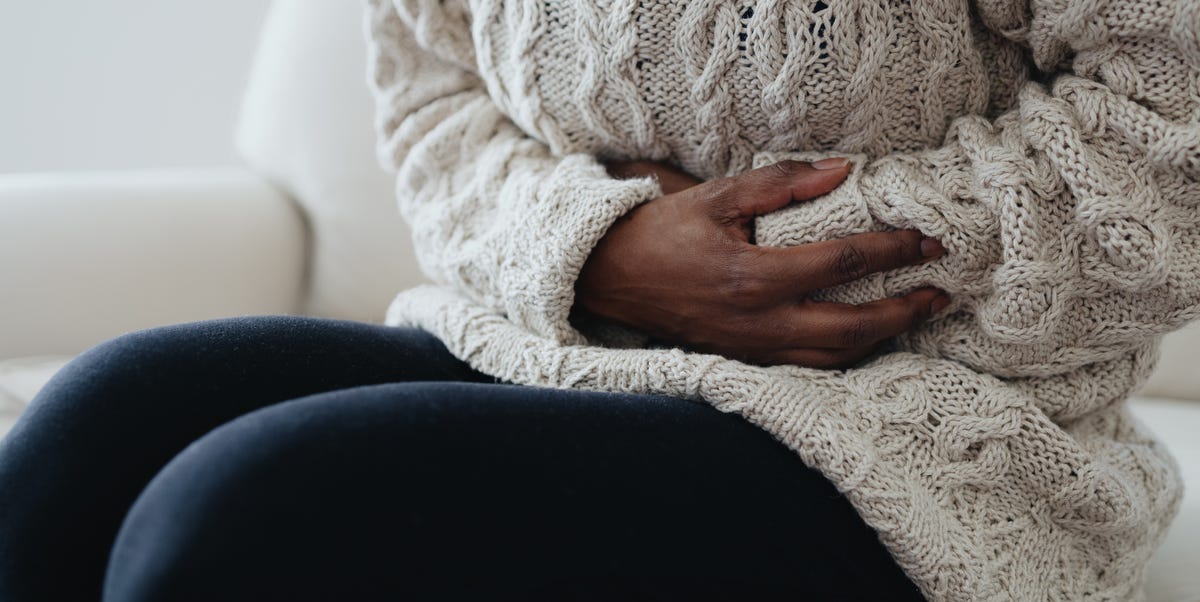 woman holds abdomen in pain royalty free image 1765996858