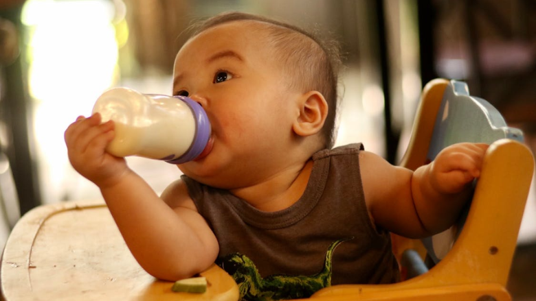 baby in high chair self feeding bottle HN NGUYN via
