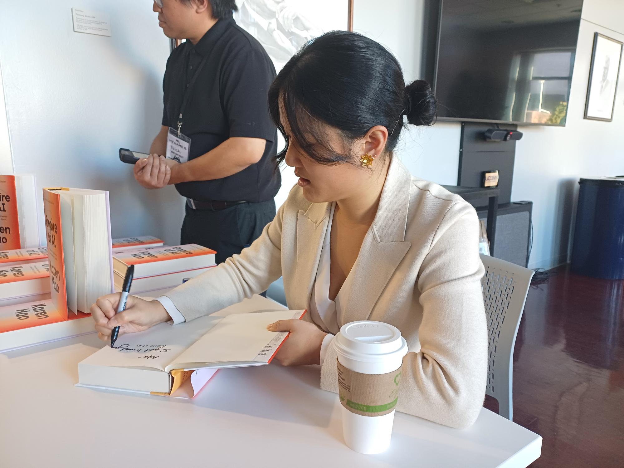 Karen Hao signing her book during the reception