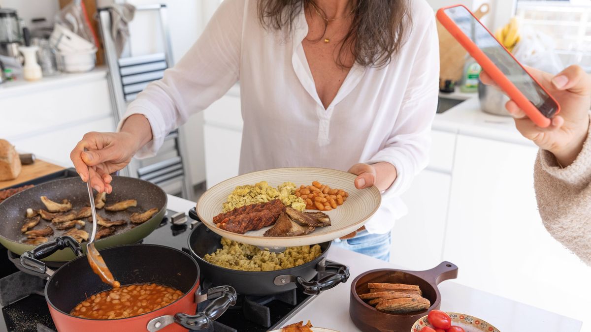 Woman swaps hash brown on full English breakfast for underrated item 5 0 Woman helps herself to an elaborate vegan breakfast while friend takes photo on cellphone