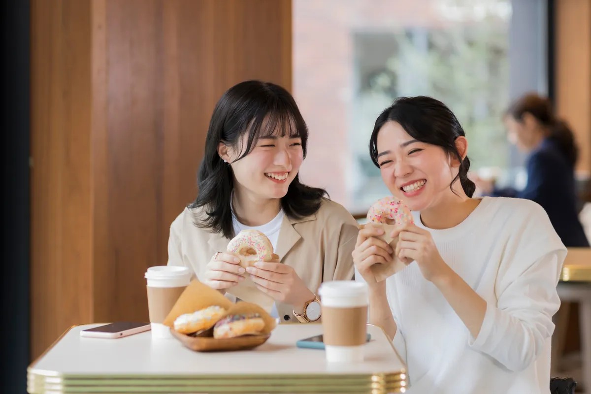 639168511926910586Two women happily eating reduced sugar sweets treats
