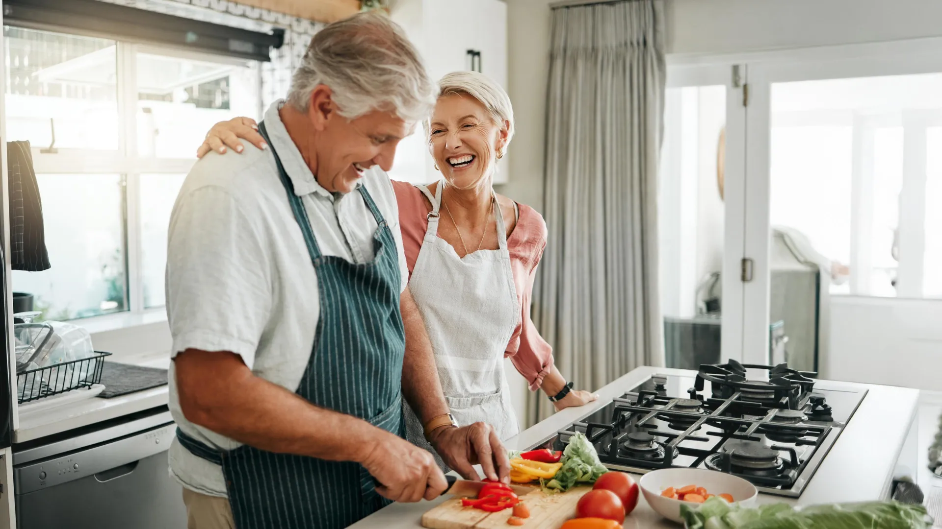 happy senior couple in kitchen cooking healthy