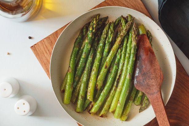 Stop boiling asparagus as it comes out tastier with 1 simple method cook loves 5 0 Top view on roasted asparagus in a white pan on a kitchen table Modern style vegetarian food
